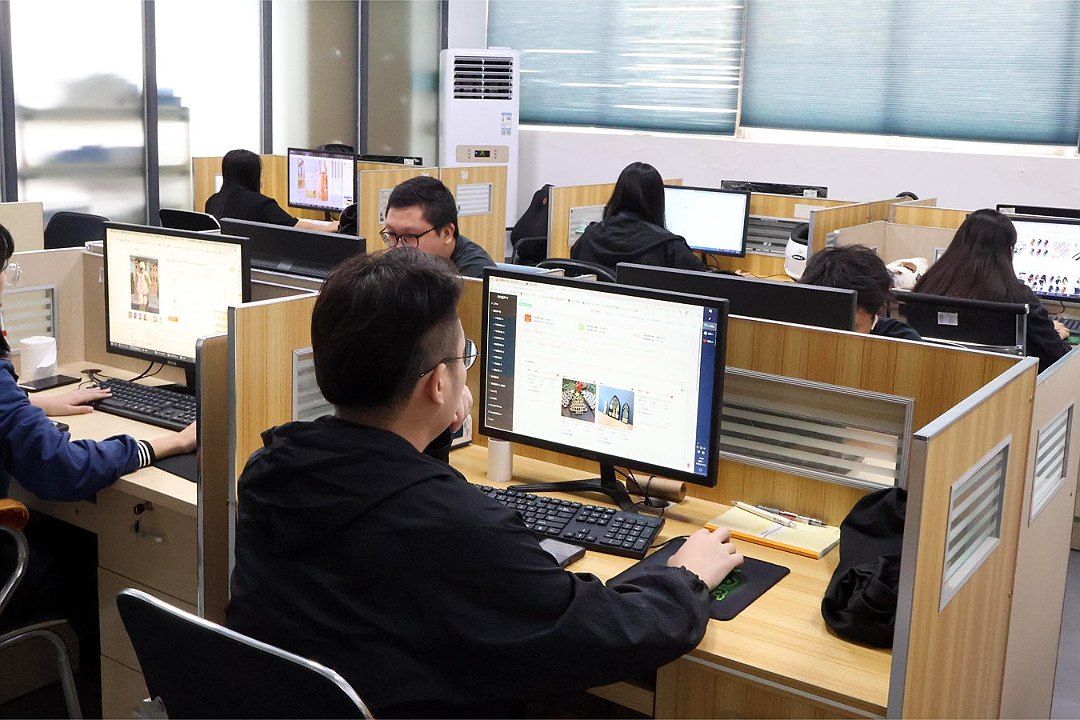 لقطة قريبة لمكتب المبيعات يظهر فيها الموظفون وهم يعملون على صور المنتجات والطلبات في …