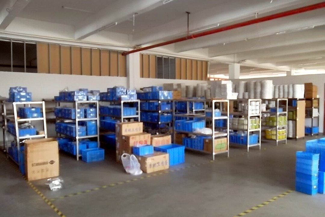 货架上整齐摆放蓝色周转箱和物料,地面黄线分区