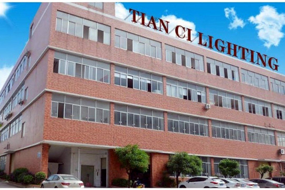 Exterior of the Tianci Hongye factory building: a multi-story red-brick facility with "TIAN CI LI…" on the roof
